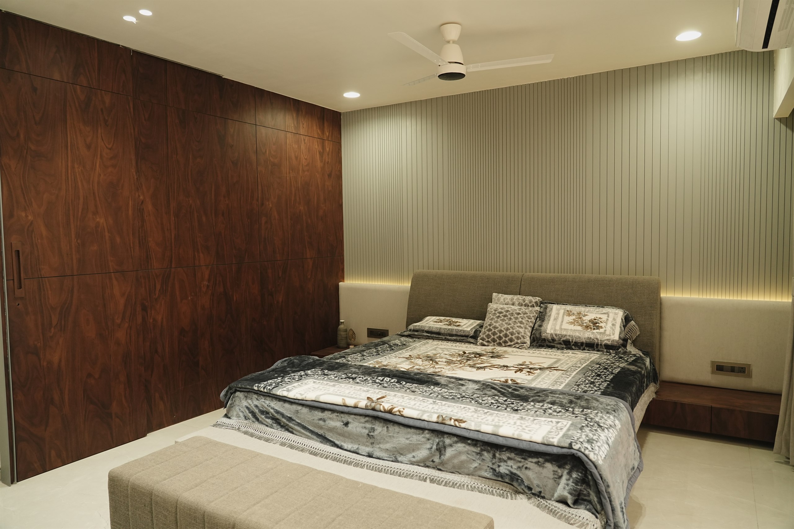 Pancholia Residence master bedroom with walnut wardrobe wall and fluted panelling